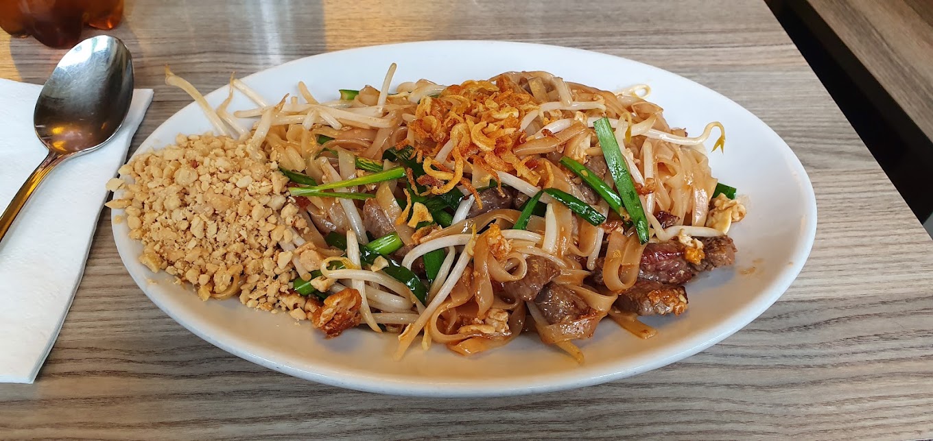 Frisch zubereitetes Pad-Thai-Nudelgericht mit Rindfleisch, Sprossen und Erdnüssen bei Takrai